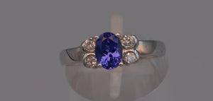 14K white gold ring with one center oval Tanzanite and four side diamonds