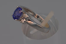 14K white gold ring with one center oval Tanzanite and four side diamonds