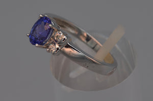 14K white gold ring with one center oval Tanzanite and four side diamonds