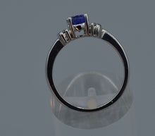 14K white gold ring with one center oval Tanzanite and four side diamonds