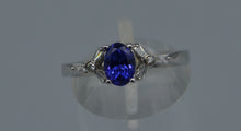 14K white gold ring with one center oval Tanzanite and six side Diamond baguettes