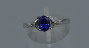 14K white gold ring with one center oval Tanzanite and six side Diamond baguettes
