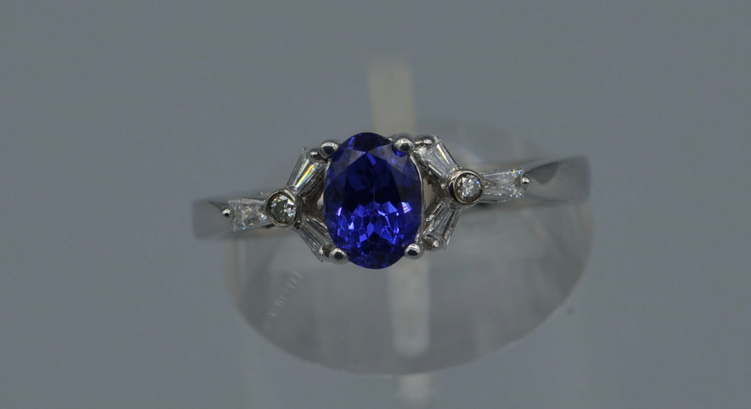14K white gold ring with one center oval Tanzanite and six side Diamond baguettes