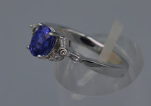 14K white gold ring with one center oval Tanzanite and six side Diamond baguettes