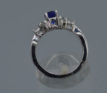 14K white gold ring with one center oval Tanzanite and six side Diamond baguettes