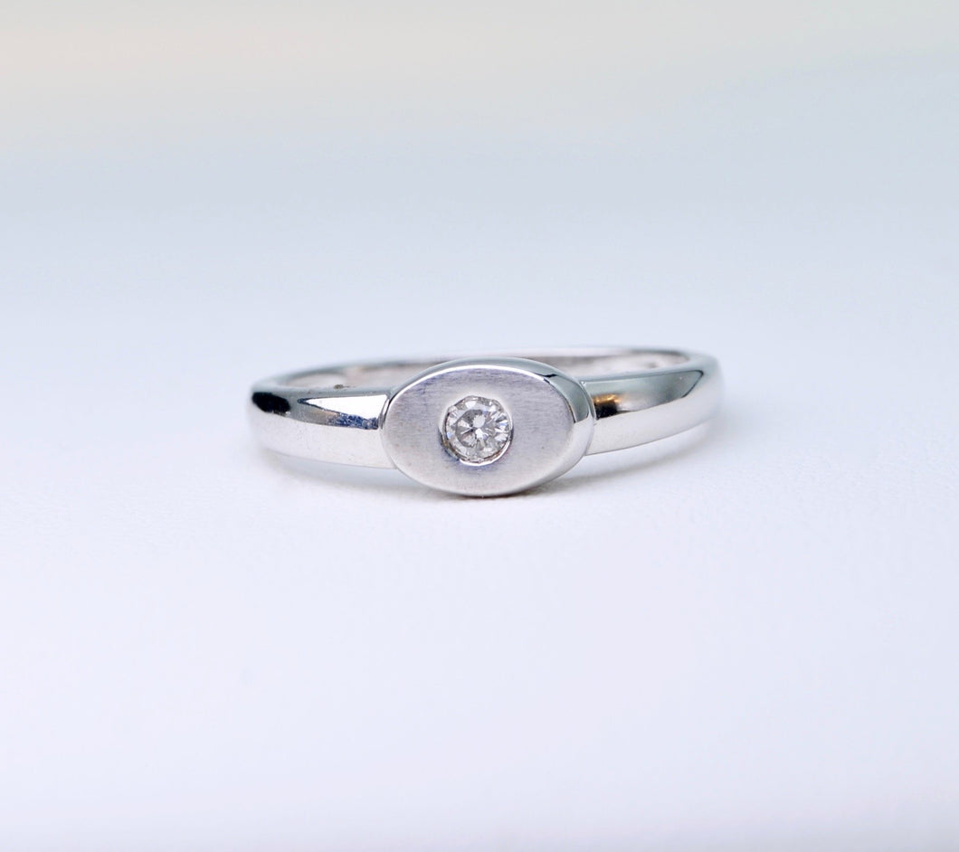 18K white gold ring with one small diamond set in an oval surface