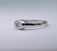 18K white gold ring with one small diamond set in an oval surface