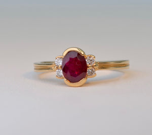 14K yellow gold ring with one center oval Ruby and four side Diamonds